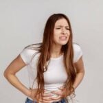 Abdominal Pain_ Distressed Woman Clutching Her Belly