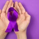 Fiocco viola tra le mani simbolo di Alzheimer