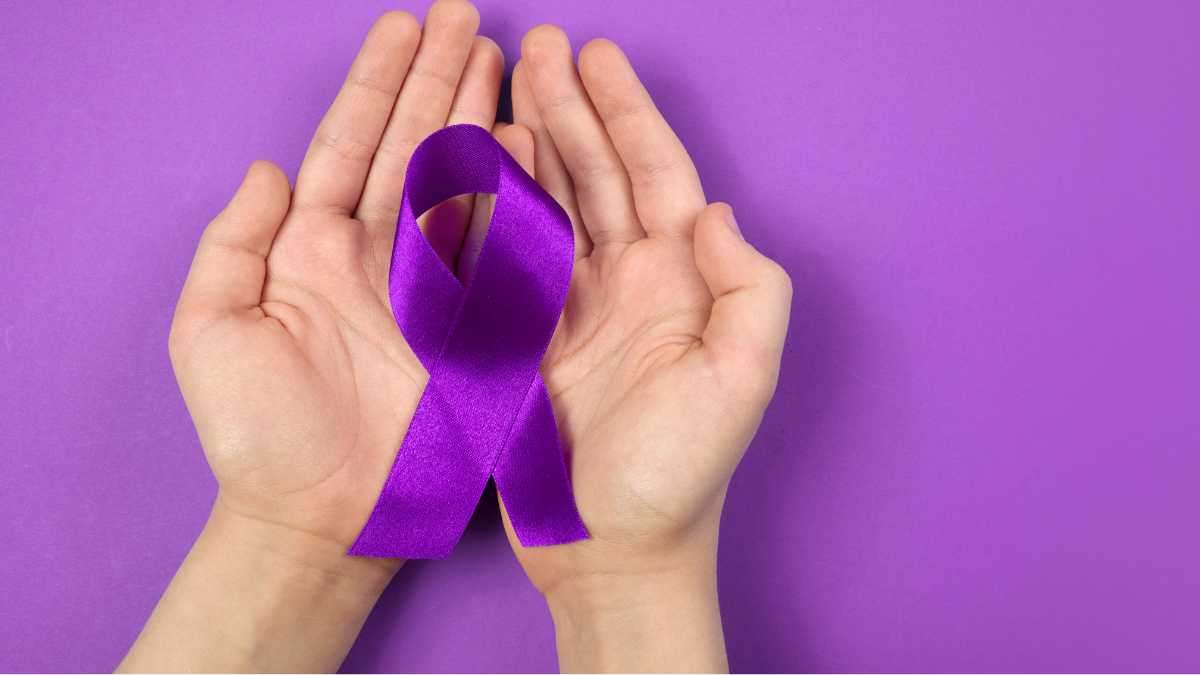 Fiocco viola tra le mani simbolo di Alzheimer