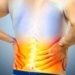 Lower Back Pain. Man Holding His Back in Pain