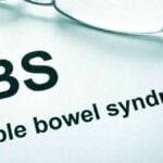 Paper with words Irritable bowel syndrome (IBS) and glasses