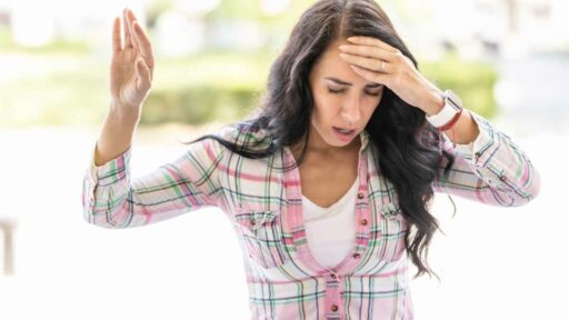 This young woman suddenly feels dizziness. Disoriented woman suffering from vertigo