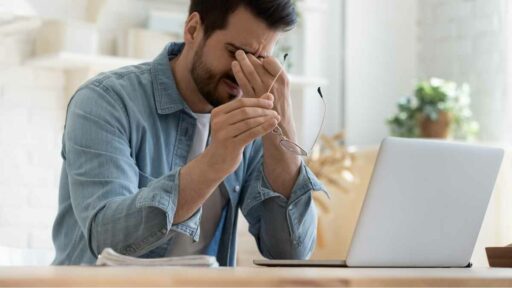 Tired young man feel eyestrain fatigue