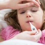 termometro digitale per misurare la febbre a una bambina
