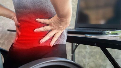 woman worker suffering from lower back pain from sitting too long