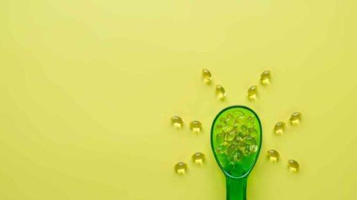cucchiaio con pillole di vitamina D a forma di sole