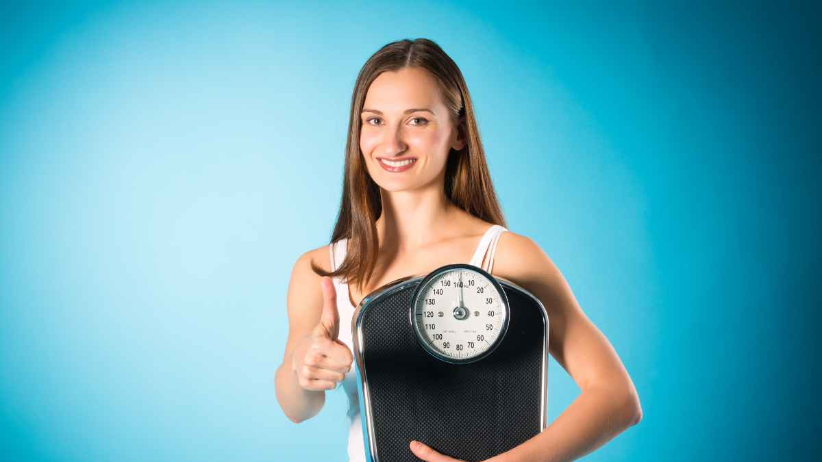 ragazza snella sorride con la bilancia in mano. peso forma raggiunto