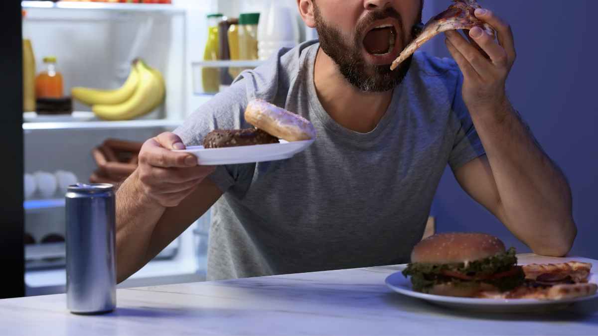 uomo mangia pizza in preda a fame nervosa