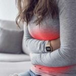 donna che abbraccia la pancia in preda ai crampi