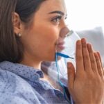 ragazza che indossa maschera di nebulizzazione per aerosol