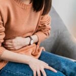 ragazza si sorregge la pancia con crampi in corso