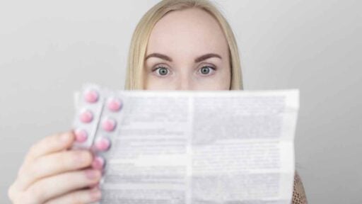 ragazza che legge bugiardino del farmaco per prevenire effetti collaterali