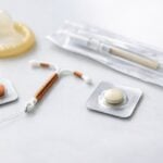Vari dispositivi medici per la contraccezione d'emergenza esposti su una superficie bianca pulita.