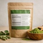 Closeup of moringa powder supplement packaging on a neutral background.